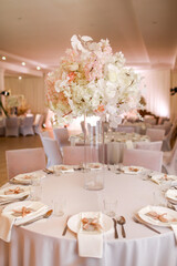 festive wedding decoration. Beautiful fresh white and pink flowers in glass vase on dining table on wedding day. High quality photo