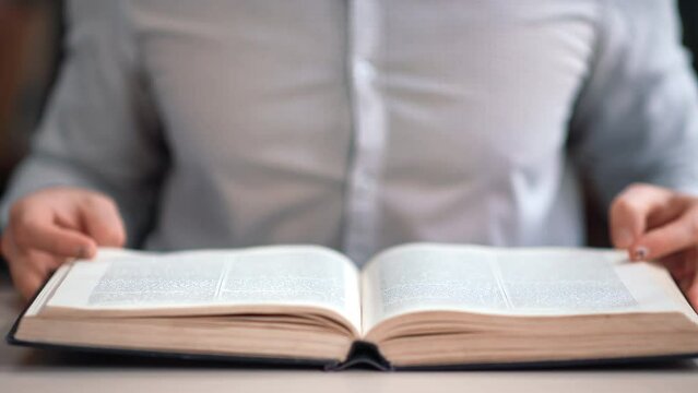 Unrecognizable man open vintage paper book searching educational information on library desk closeup