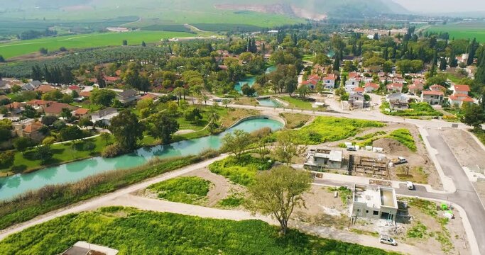 Aerial view of the town with hills in the background and Kibbutzim Stream, Nir David, Northern District, Israel.