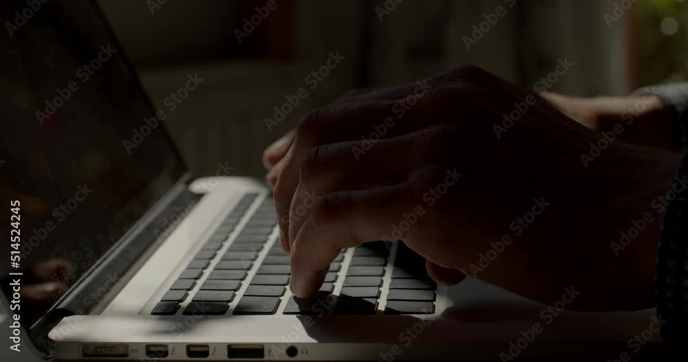 Fototapete light spot on a laptop keyboard. he presses buttons, prints text. writing a letter using a computer.