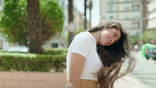 Young hispanic woman smiling confident standing at park