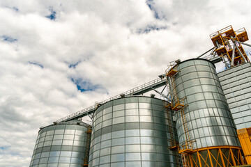 A large modern plant for the storage and processing of grain crops. view of the granary on a sunny day against the blue sky. End of harvest season.