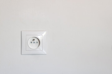 New electrical socket isolated on gray wall. Empty copy space white plastic power outlet. Close-up view of electric outlets.