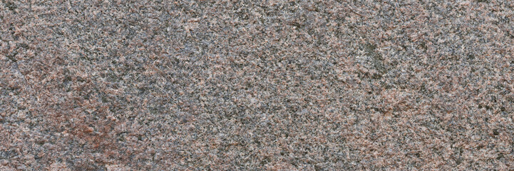 Granite texture. Natural pink granite with a grainy pattern. Stone background. Solid rough surface of rock. Durable construction and decoration material. Close-up.