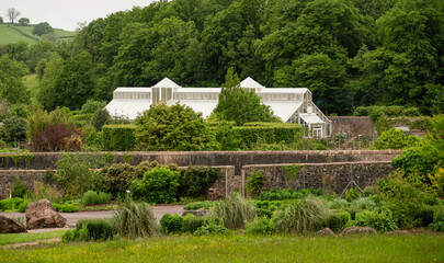 Large tropical greenhouse with two glass turrets set amongst botanical gardens