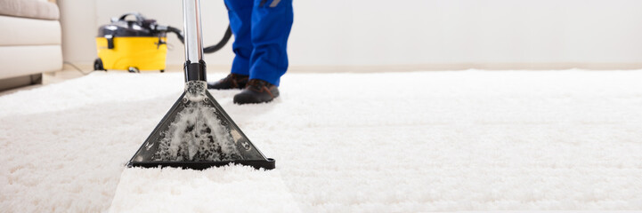 Janitor Cleaning Carpet With Vacuum Cleaner