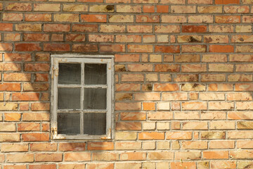 Fototapeta na wymiar Altes Fenster in Haus mit Ziegelsteinwand, rote Ziegel, Hintergrund