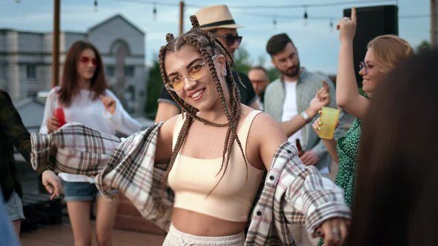 Hipster woman dancing roof party surrounded by positive friends overjoyed people crowd