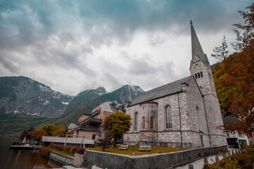 Church rising next to the old town of Hallstatt in Central Austria on a cloudy day in autumn. Picturesque village in Austria.