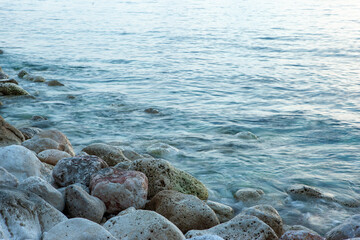 Sea stoney beach on sunset. Stone coastline. Rocky beach seascape for publication, poster, calendar, post, screensaver, wallpaper, postcard, postcard, banner, cover, website. High quality photo