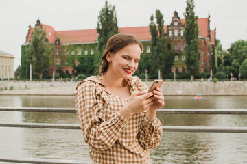 beautiful woman texting on the embankment