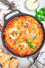 Sausage Shakshuka with eggs, Italian sausage, tomato sauce, in cast iron pan, vertical, top view