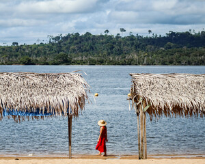 Mulher caminhando na praia do Massanori, Altamira, pará, com rio xingu ao fundo
