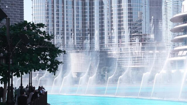 Dancing fountains near Burj Khalifa skyscraper in Dubai. World's largest fountains with the height of up to 150 m during sunny day. 