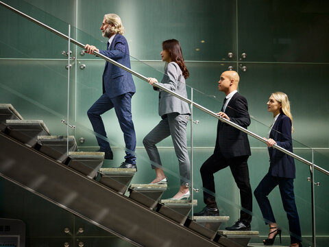 multiethnic business people walking on steps in modern office