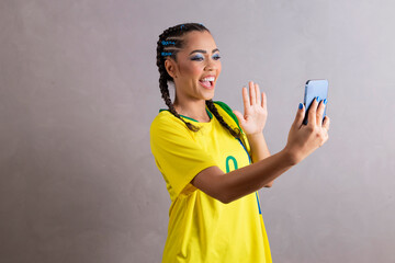 Brazilian fan woman cheering for brazil at world cup 2022 on video call talking to friends...