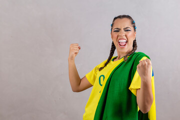 Brazilian supporter. Brazilian woman fan celebrating on soccer or football match on grey...
