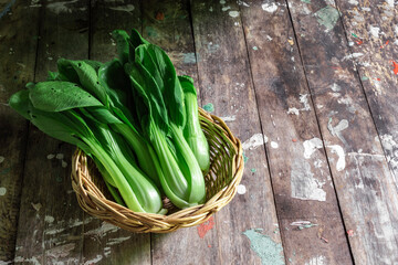 Healthy vegetable bok choy in basket on wood table.