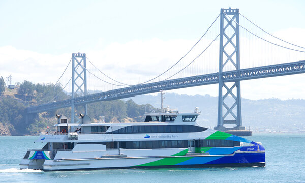 San Francisco, CA - May 7, 2022: San Francisco Bay Ferry HYDRUS in the Bay with the Bay Bridge and Treasure island in the background..