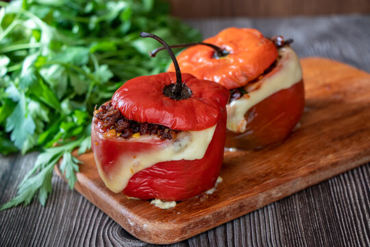 Stuffed pepper Rocoto relleno with baked meat and melted cheese on a wooden board