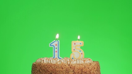 Cake with lighted candle number 15. Green screen background. Isolated.