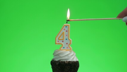 Lighting the number 4 birthday candle on a delicious cupcake. Green screen