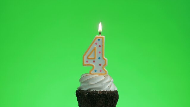 Lighting the number 4 birthday candle on a delicious cupcake. Green screen