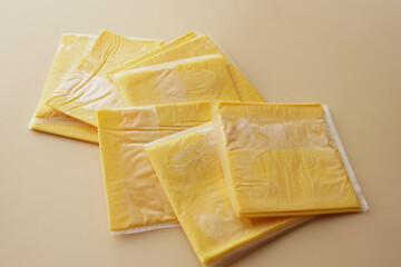 Transparent packet with slices of cheese on yellow ,