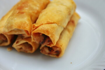 Fried spring rolls placed in a white plate, fried spring rolls are a popular Asian dish.