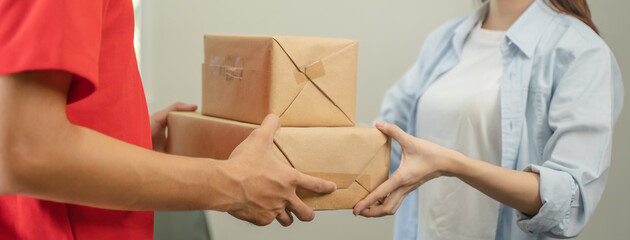 Close up hand of delivery man send package box to receiver.