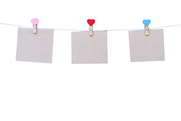 Blank brown paper hanging on tree  wood clothes pegs (heart shape patterns) hang on white string...