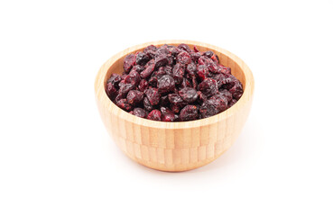 Dried cranberries in woodle bowl isolated on white background.
