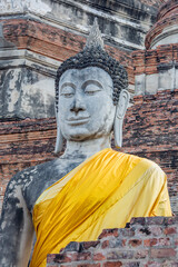 A big Buddha statue with yellow kasaya in Wat Yai Chai Mongkhon , a Buddhist temple in Ayutthaya Thailand. 
The monastery was constructed by King U-Thong in 1357 AD. 