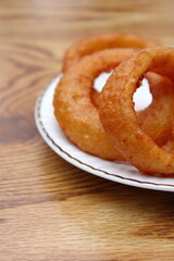 Fried onions served in small white plates in American restaurants.