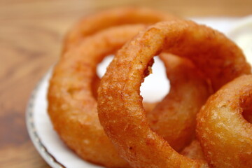 Fried onions served in small white plates in American restaurants.