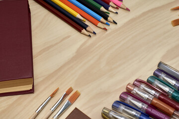 Fototapeta premium books pencils fountain pens and brushes for drawing on the table concept education school