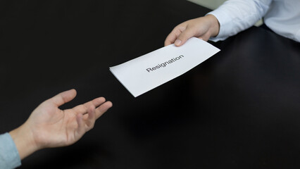 Employee submits the resignation letter envelope to the head of personnel, Carrying a box of work equipment home, Can't bear the burden or pressure, Employment contract is expired.