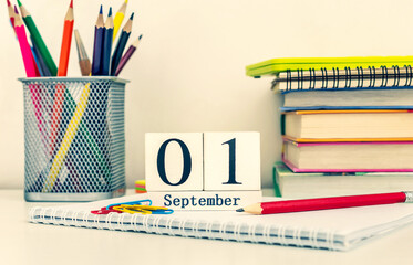Date of 1 september and school supplies on the desk near wall. Back to school. Toned image.