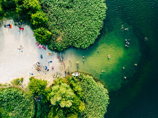 Summer time at the lake. Rest on the beach. Aerial view of small hidden beach. - obrazy, fototapety, plakaty