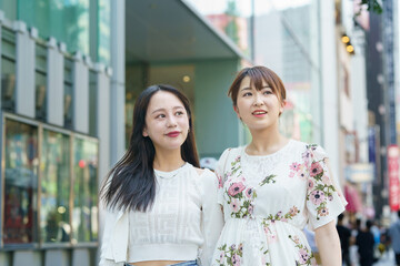 Fototapeta premium 都会で友達とショッピングする女性
