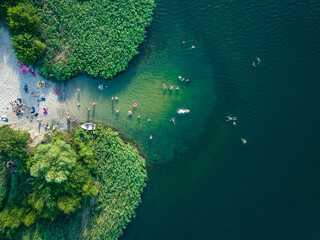 Summer time at the lake. Rest on the beach. Aerial view of small hidden beach.