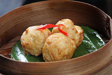 Fried meatball dimsum, served in a round bamboo container. Typical traditional Chinese dimsum serving container