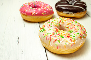 donuts of different colors on a white table