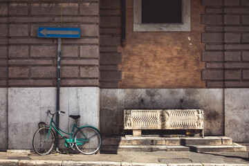 Old bicycle near an ancient Roman drinking fountain. Vintage atmosphere in the city center of Rome.
