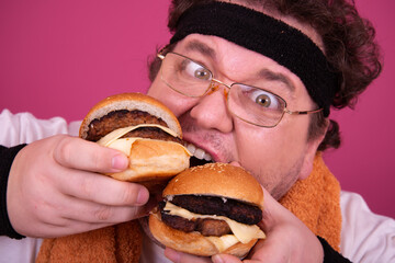 Diet, fitness and healthy lifestyle. Funny fat man eating a burger.