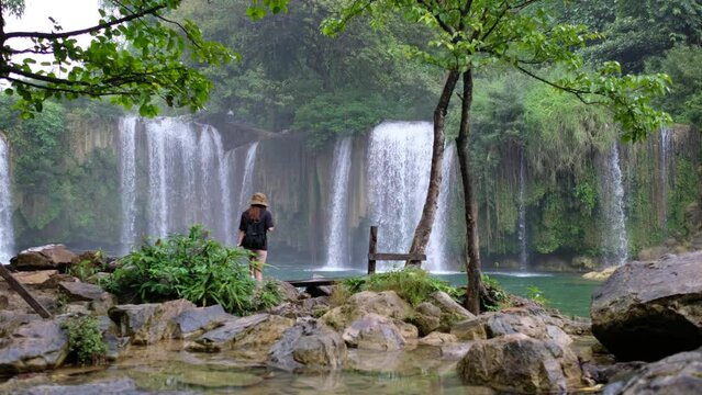 A young woman traveling and walking into Glue Thor waterfall in Kayin state, Myanmar