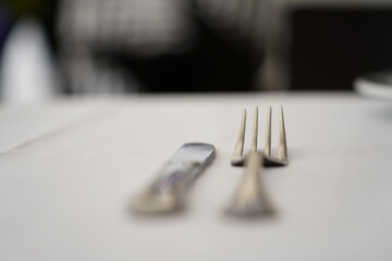 knife and fork placed on a table in the restaurant. detail.