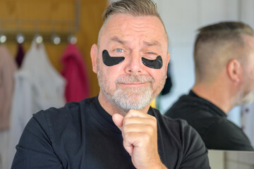 Man using cosmetic hydrating patches under his eyes