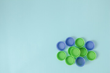 top view of plastic bottle caps with copy space on a blue background. recycling to conserve the environment