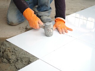 Construction worker laid floor tiles.